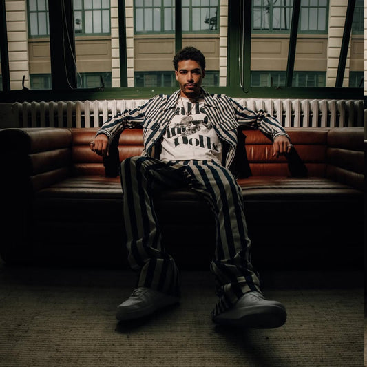 Person sitting on a couch in a room with large windows and 'Preme' branding.